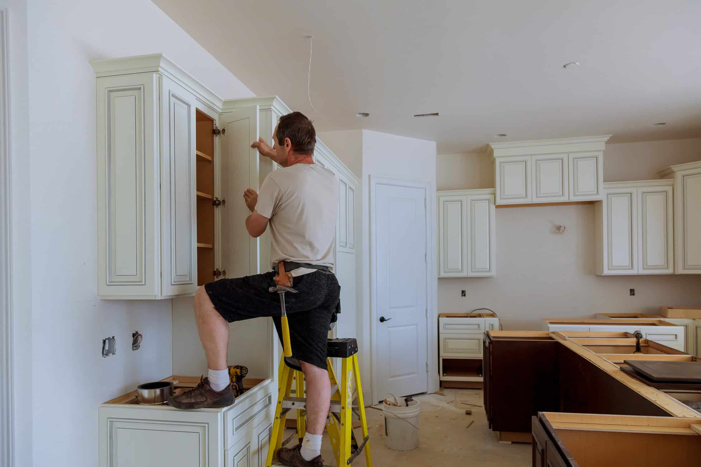 Man installing kitchen cabinets door installation of kitchen